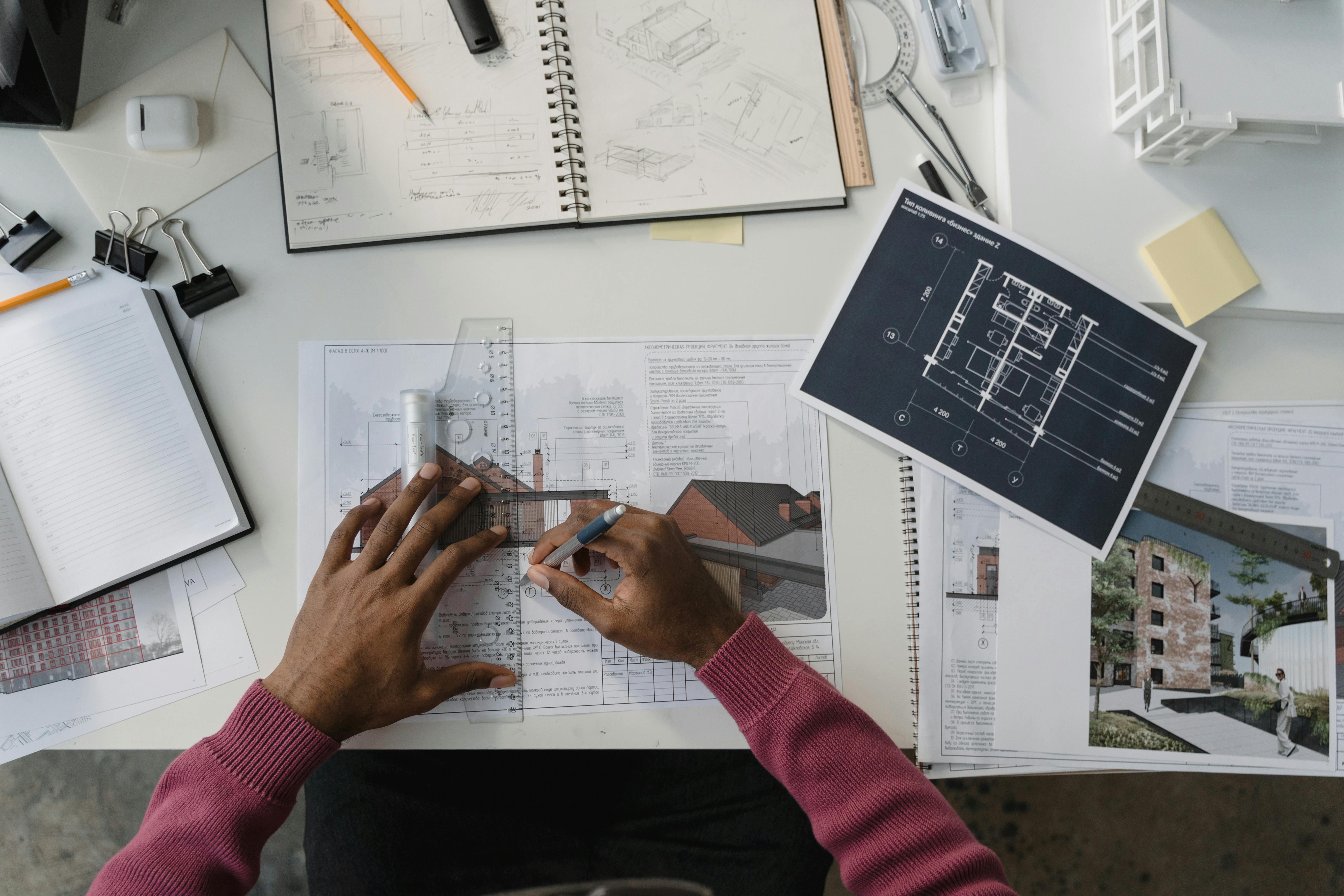 Architect working on technical drawings at a desk