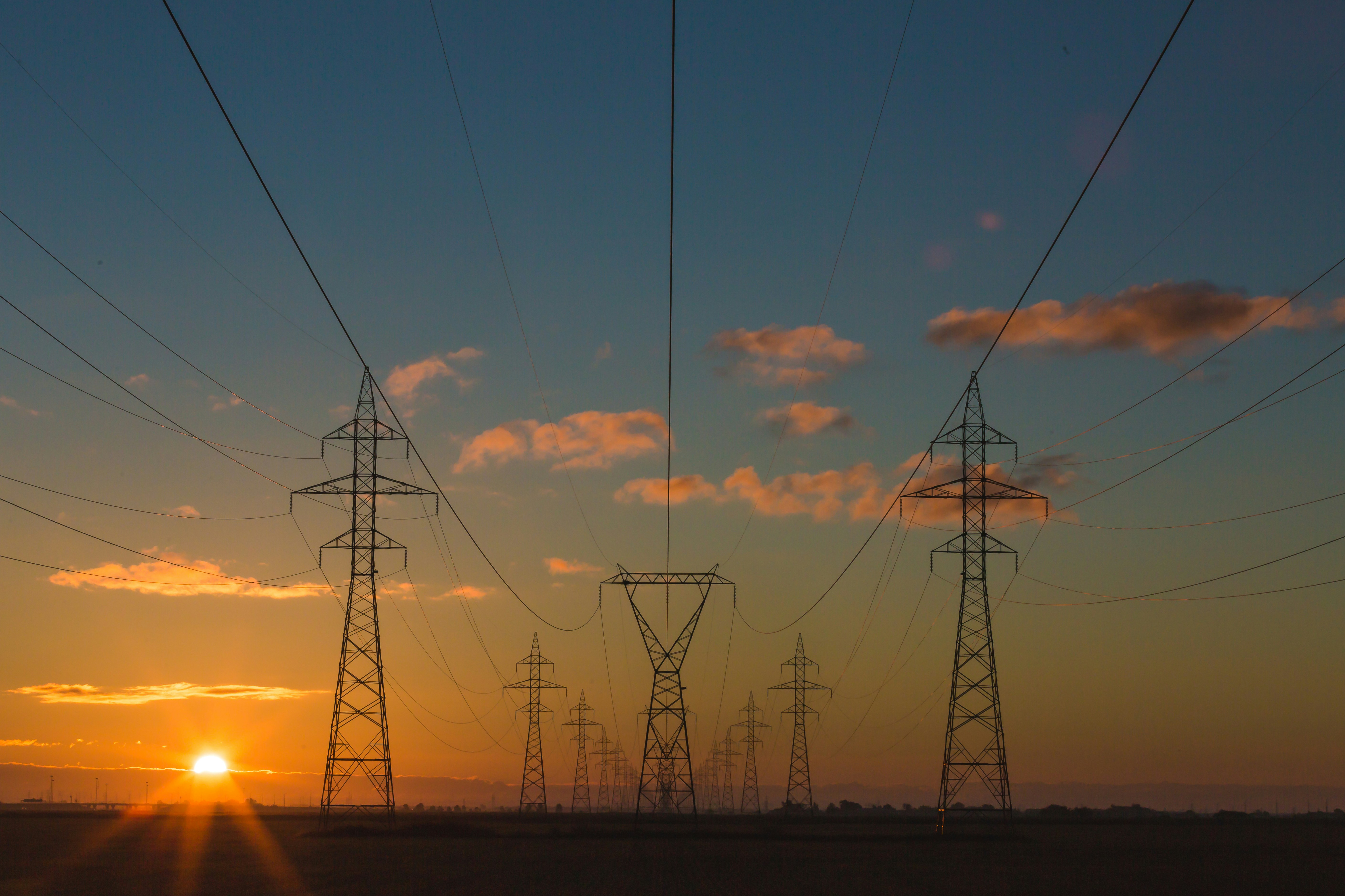 Power lines at sunset representing energy and infrastructure